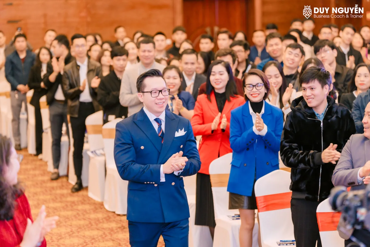 Một hội trường đông người đứng vỗ tay